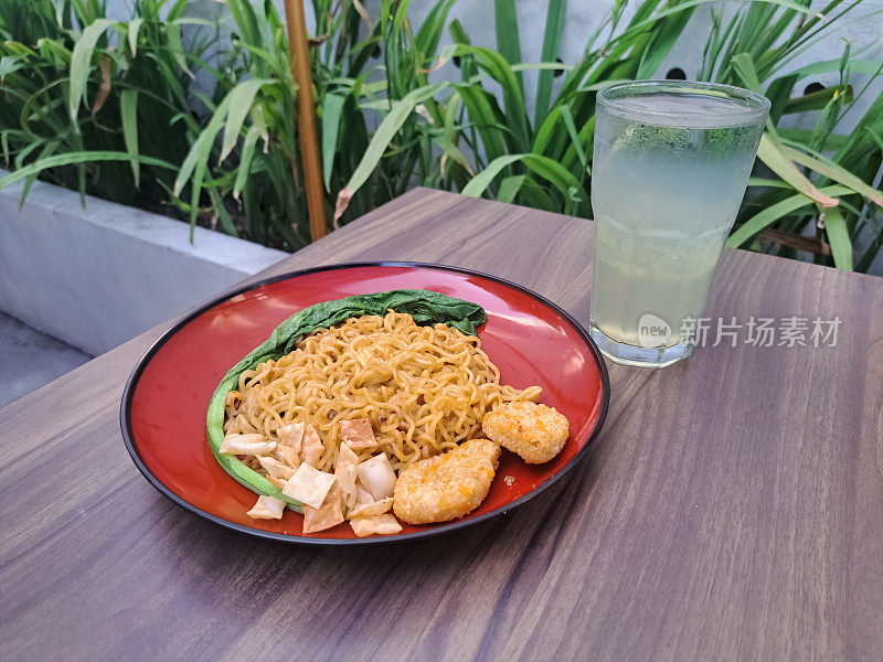 即食炸面配鸡块、炸饺子、芥菜绿和酸橙清凉饮料。Mie Goreng Instant Dan Minuman Jeruk Nipis Dingin。食物和饮料菜单。